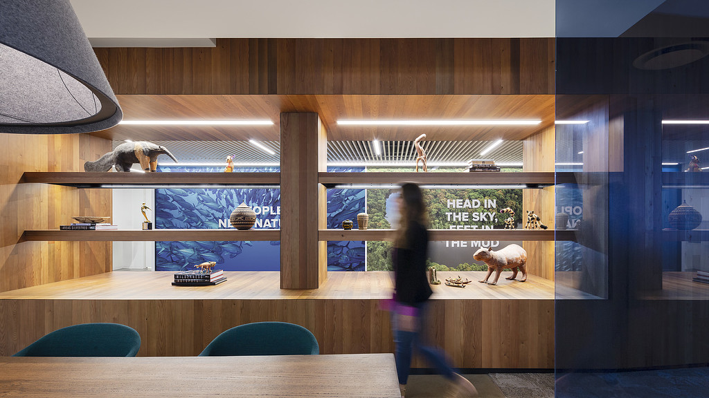 A person walking in a room with a table and chairs.